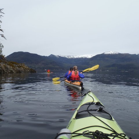 a man riding on the back of a boat in the water