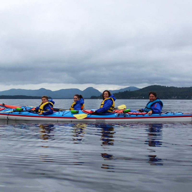 a group of people rowing a boat in the water