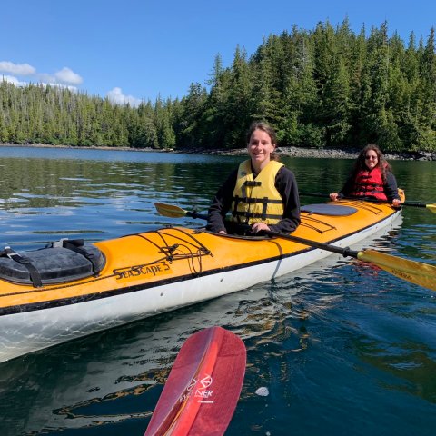 a group of people riding on the back of a boat in the water