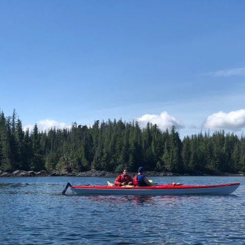 a group of people rowing a boat in a body of water