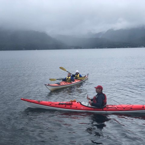 a group of people in a small boat in a body of water