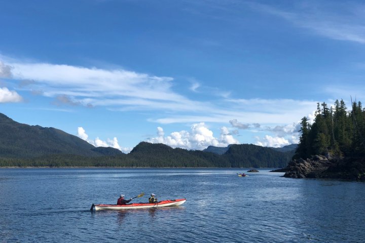 a small boat in a body of water with a mountain in the background