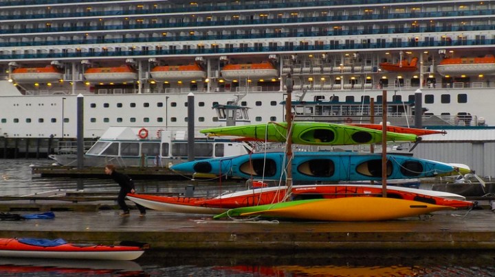KayaksandcruiseshipinKetchikan a boat is docked next to a body of water