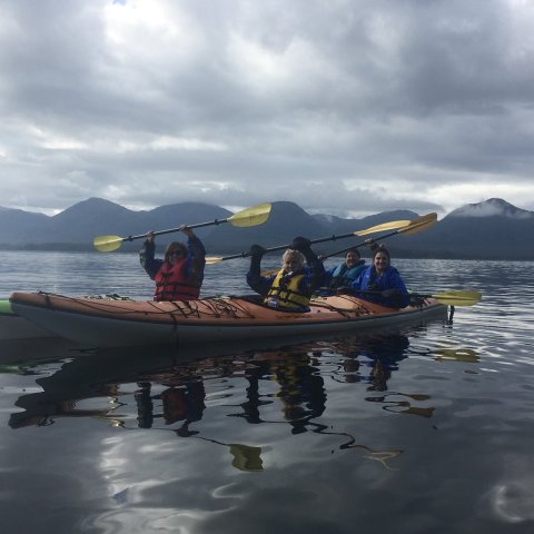 a group of people sitting in a boat on a body of water