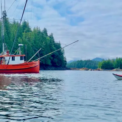 Sea Kayaking past a commercial salmon fishing boat at Orca Cove near Ketchikan, Alaska